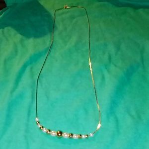 white and gold pearls on a gold plated necklace.